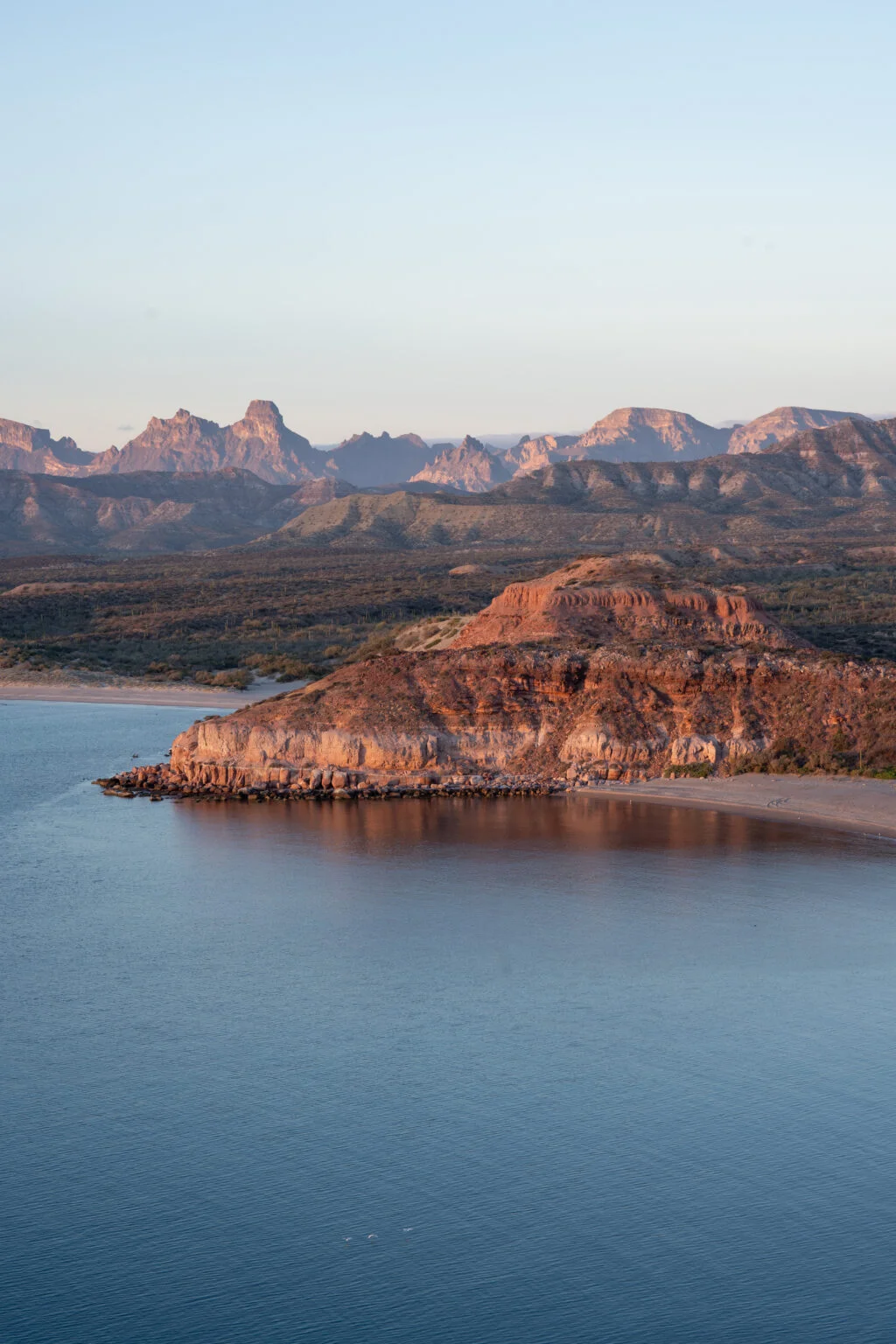 Loreto La Paz Beautiful red cliff stretching towards the sea with an impressive backdrop of mountains